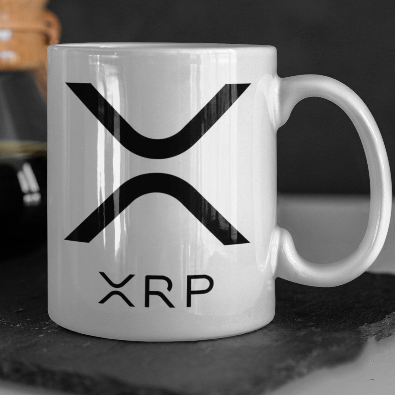 White mug with XRP logo on a dark surface